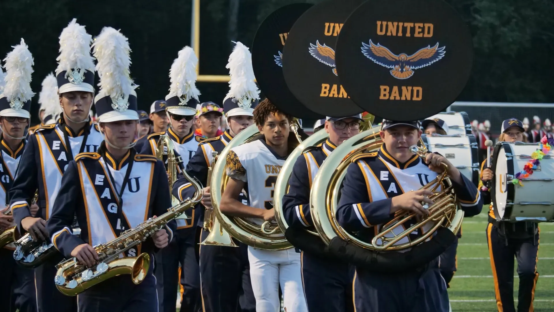Brass and saxophones marching under the United Band banner